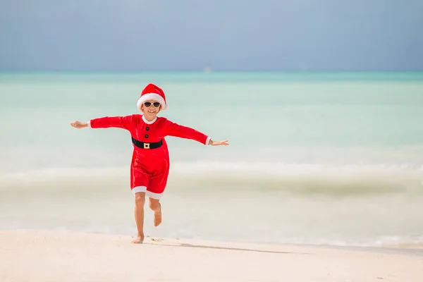 Nuttet lille pige i Santa hat på tropisk strand - Stock-foto