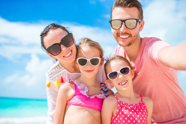 Família feliz na praia durante as férias de verão — Fotografia de Stock