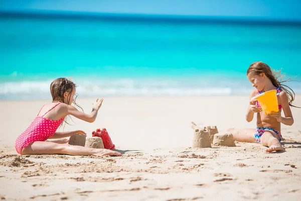 Двое детей делают песочный замок и веселятся на пляже — стоковое фото