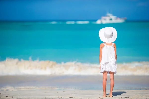 Adorable little girl in big red hat on the beach — Stock Photo, Image