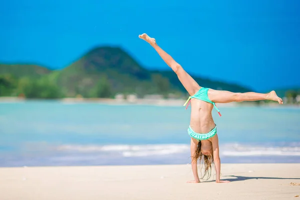 Schattig actief klein meisje aan het strand tijdens de zomervakantie — Stockfoto