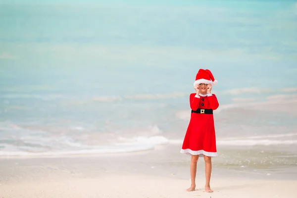 Rozkošná holčička v santa hat na tropické pláži — Stock fotografie