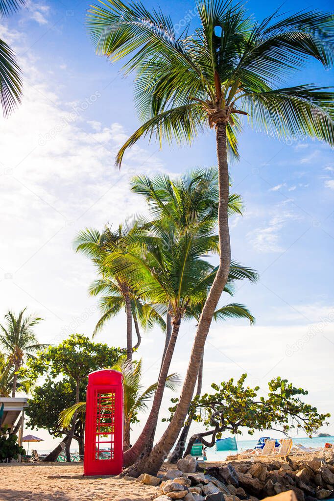 Beautiful landscape with a classic phone booth on the white sandy beach in Antigua