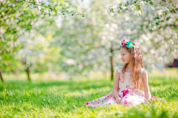 Entzückende kleine Mädchen im blühenden Apfelbaumgarten am Frühlingstag — Stockfoto