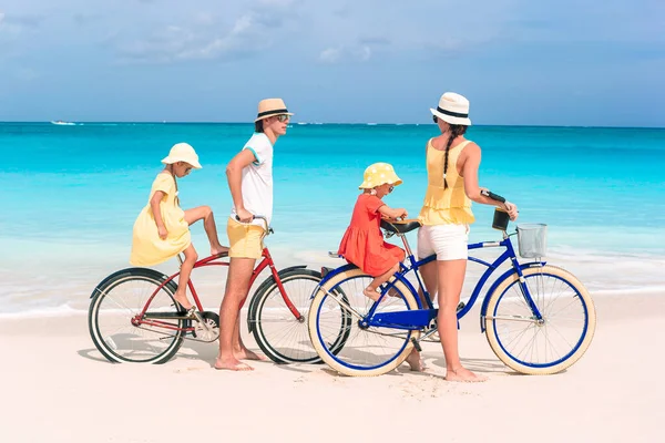 Family with a bike on tropical beach — Stock Photo, Image