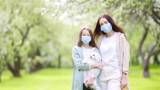 Familia de madre e hija en floreciente jardín de cerezos en máscaras — Vídeos de Stock