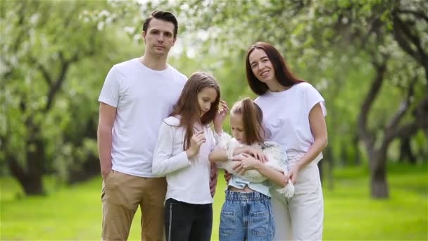 Bedårande familj i blommande körsbärsträdgård på vacker vårdag — Stockvideo