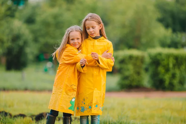 Schattige kleine meisjes onder de regen op warme lentedag — Stockfoto