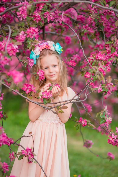 Adorable niña en el jardín de manzanas en flor en hermoso día de primavera —  Fotos de Stock