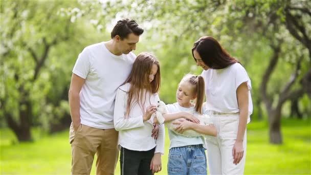 Schattige familie in bloeiende kersentuin op mooie lentedag — Stockvideo