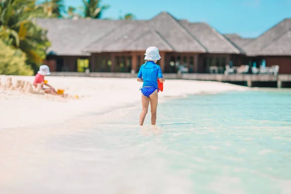 Two kids making sand castle and having fun at tropical beach — Stock Photo, Image