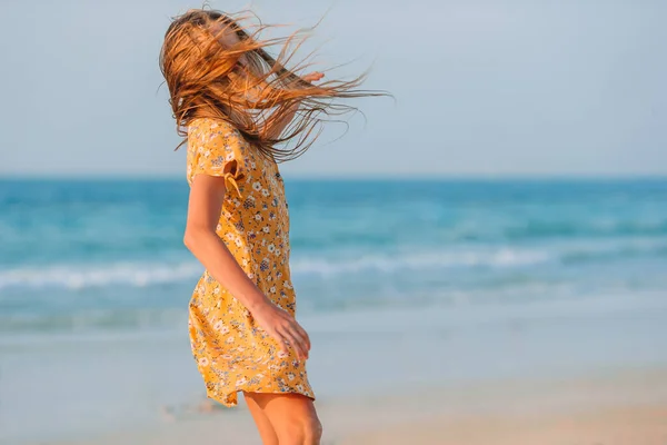 Adorable niña feliz en la playa blanca al atardecer. —  Fotos de Stock