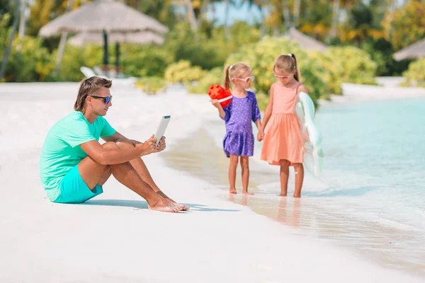 Babalarının yüzmek ve sahilde eğlenmek için laptopla çalışmasını bekleyen üzgün çocuklar. — Stok fotoğraf