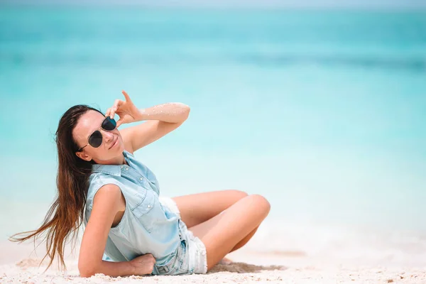 Mujer tendida en la playa disfrutando de vacaciones de verano —  Fotos de Stock