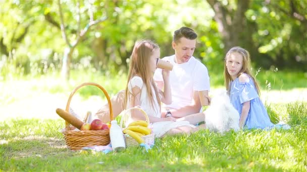 Père heureux et petites filles se détendre au bord du lac — Video