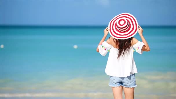 Jonge mooie vrouw op wit zand tropisch strand. Achteraanzicht van Kaukasisch meisje in hoed achtergrond de zee — Stockvideo