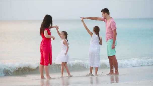 Parents et adorables deux enfants ont beaucoup de plaisir pendant leurs vacances d'été sur la plage. Famille de quatre personnes amoureuse, heureuse et belle . — Video