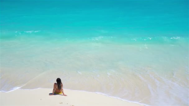 Jonge vrouw op het strand met uitzicht op het water boven — Stockvideo