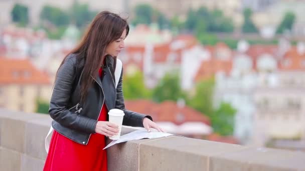 Gelukkige jonge stedelijke vrouw die koffie drinkt in de Europese stad. Reizen toeristische vrouw met warme drank buiten tijdens vakantie in Europa. — Stockvideo