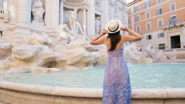 İtalya 'daki Roma gezisi sırasında Trevi Çeşmesi' ne bakan güzel bir kadın. Kız Avrupa tatilinin tadını çıkarıyor