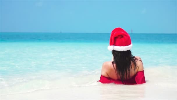 Vrouw met kerstmuts in bikini op tropisch strand. Langzame beweging. — Stockvideo