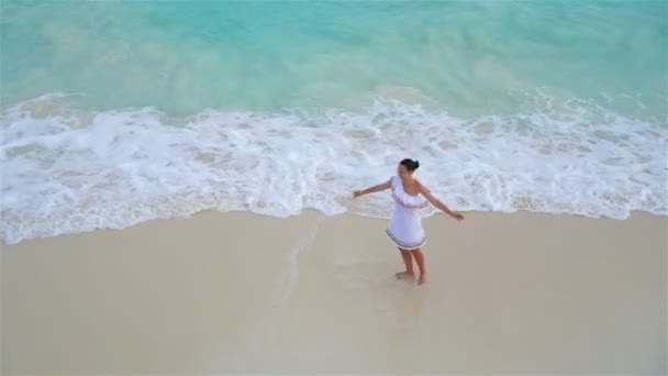 열대 해안에 사는 아름다운 소녀. 하얀 해변에서 아름다운 옷을 입은 행복 한 소녀의 모습 위 — 비디오