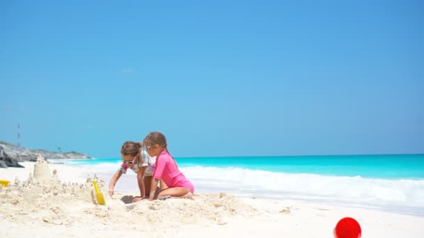 Niños pequeños y felices jugando con juguetes de playa durante las vacaciones tropicales — Vídeo de stock