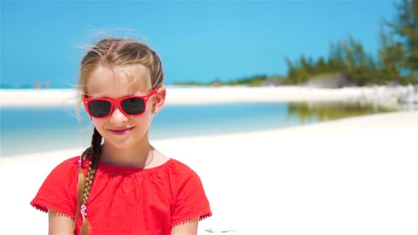 Aranyos kislány portréja a tengerparton a nyári vakáció alatt. Lassú mozgás — Stock videók