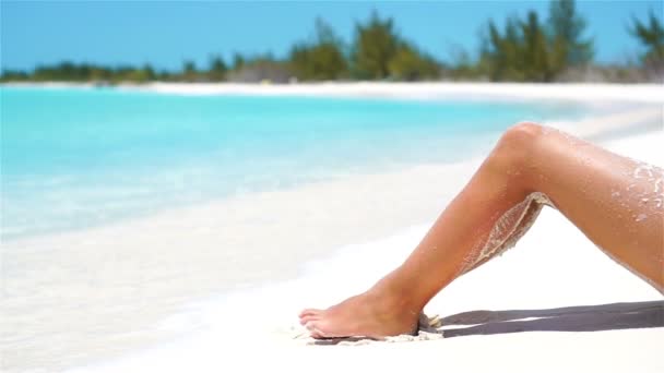 Θηλυκά λεπτά μαυρισμένα πόδια σε μια λευκή τροπική παραλία. SLOW VIDEO — Αρχείο Βίντεο