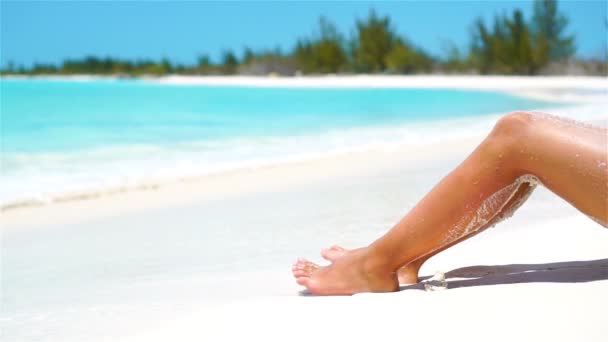 Női karcsú barna lábak egy fehér trópusi strandon. Lassú VIDEO — Stock videók