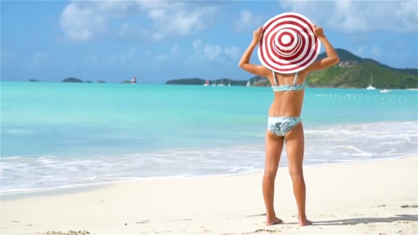Schattig klein meisje met grote hoed op het strand — Stockvideo