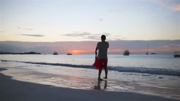 Liten flicka och glad pappa har roligt vid solnedgången under strandsemester — Stockvideo
