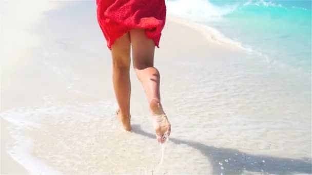 Pernas fechadas correndo ao longo da praia branca em águas rasas. Conceito de férias na praia e descalço. LOW MOTION . — Vídeo de Stock