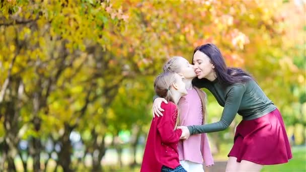 Family of mom and kids in fall. Young mother and little girls enjoy warm autumn — Stock Video