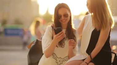 Beyaz kızlar selfie çekiyorlar. Yumuşak günbatımı ışığı. Genç turist arkadaşlar mutlu bir şekilde hafta sonunun tadını çıkarırlar..