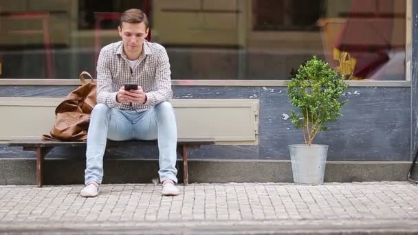 Homme envoyant un message par son smartphone à l'extérieur dans la rue. Homme utilisant un smartphone mobile . — Video