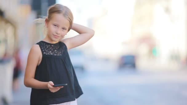 Adorable niña con teléfono inteligente al aire libre en la ciudad europea, Roma, Italia — Vídeo de stock