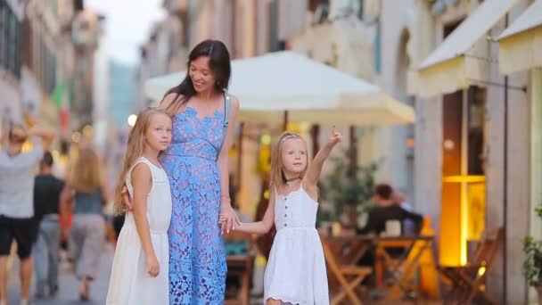 Feliz madre y niñas adorables en la acogedora calle durante las vacaciones italianas. Vacaciones europeas familiares . — Vídeos de Stock