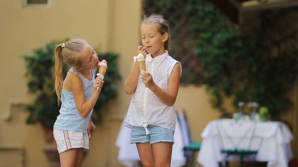 Söta små flickor som äter glass utomhus på sommaren. Söta barn njuter av äkta italiensk gelato nära Gelateria i Rom — Stockvideo