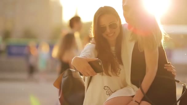 Filles caucasiennes faisant fond selfie lumière douce coucher de soleil. Jeunes amis touristiques profiter week-end en plein air souriant heureux . — Video