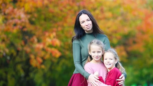 Молодая мать и две ее маленькие дочери в осеннем парке — стоковое видео
