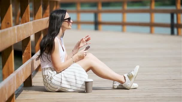 Feliz joven mujer urbana trabajando y bebiendo café en la ciudad europea al aire libre — Vídeos de Stock