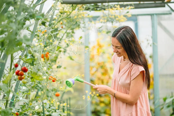 Schöne junge Frau bei der Gartenarbeit im Gewächshaus — Stockfoto
