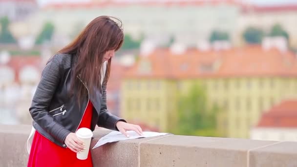 Молодая туристка с картой города ищет аттракцион на открытом воздухе. Путешественница с картой на руках во время отпусков в Европе . — стоковое видео