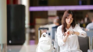 Havaalanı lobisindeki yolcu uçuş için bekliyor. Beyaz kadın bekleme odasında zaman geçirmek istiyor.