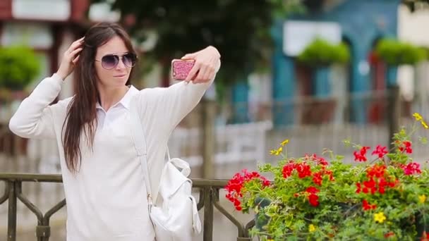 Mujer joven tomando autorretrato de fondo hermosa casa en la ciudad europea. Turista caucásica disfruta de sus vacaciones de verano europeas en Europa . — Vídeos de Stock