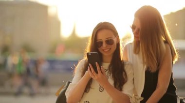 Beyaz kızlar selfie çekiyorlar. Yumuşak günbatımı ışığı. Genç turist arkadaşlar mutlu bir şekilde hafta sonunun tadını çıkarırlar..