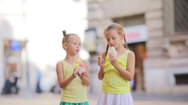Yazın dışarıda dondurma yiyen sevimli küçük kızlar. Şirin çocuklar Roma 'da Gelateria yakınlarında İtalyan dondurması yiyorlar.