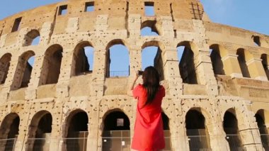İtalya, Roma 'da kolezyumun önünde fotoğraf çeken genç bir kadın. Dünyanın en popüler yerinin anısına fotoğraf çeken bir kız.