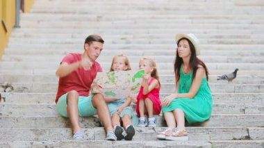 Avrupa 'da aile tatili. Aileler ve çocuklar ellerinde turistik haritayla ilgi odağı arıyorlar.